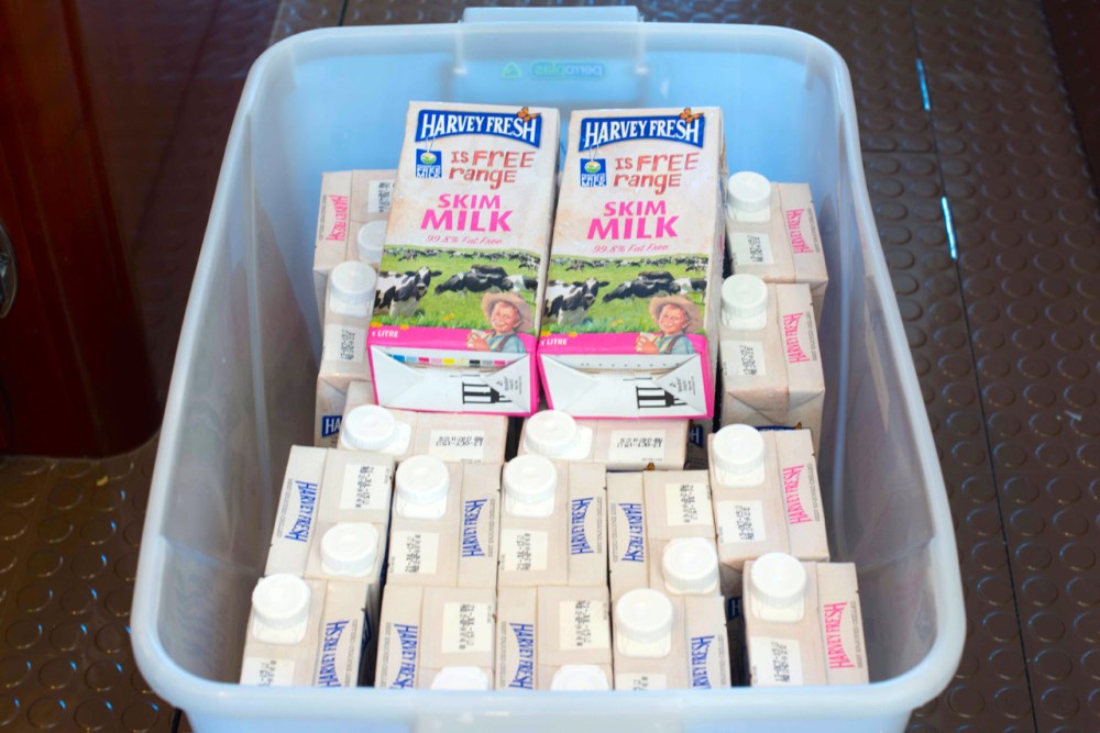 Bins of food stores like this UHT milk are stowed in the 'basement,' their contents recorded on a spreadsheet.